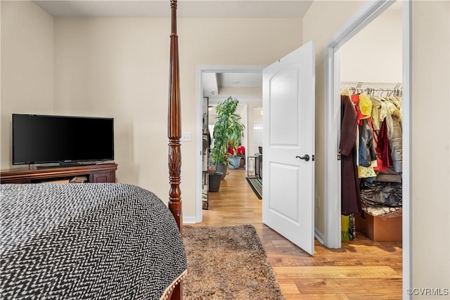 bedroom with light hardwood / wood-style floors and a closet