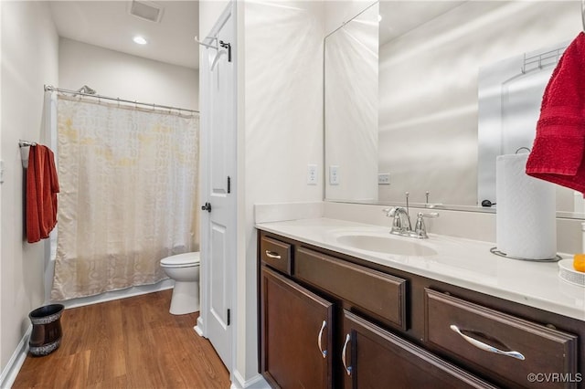 full bathroom featuring hardwood / wood-style flooring, toilet, vanity, and shower / tub combo