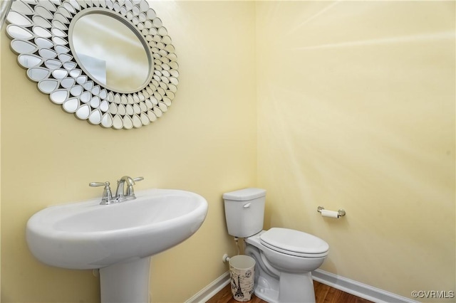 bathroom with sink, wood-type flooring, and toilet