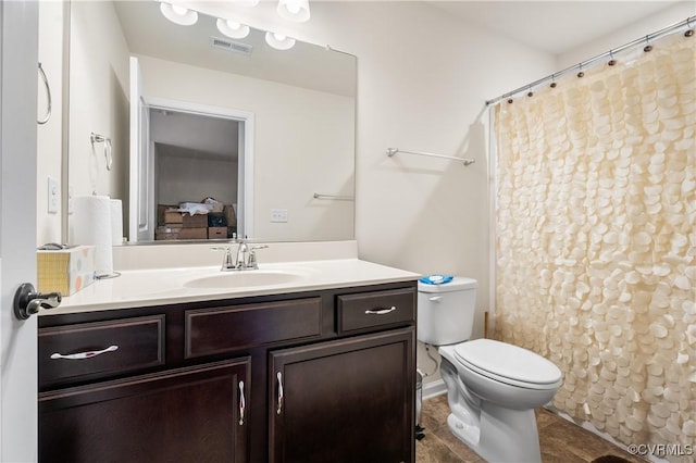 bathroom with toilet, vanity, and a shower with shower curtain