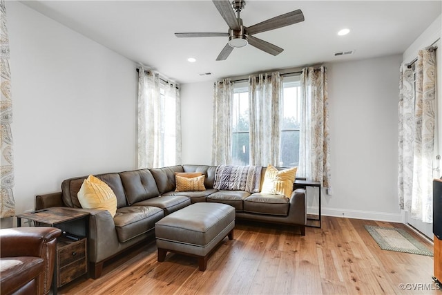 living room with ceiling fan and light hardwood / wood-style flooring