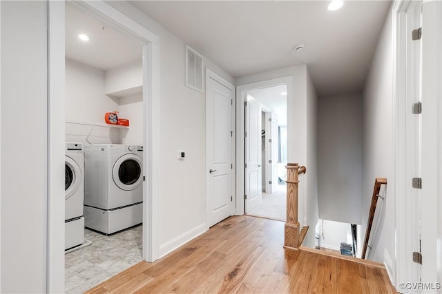 laundry room with washer and dryer and light wood-type flooring