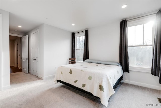 bedroom featuring multiple windows and light carpet