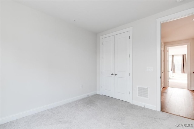 unfurnished bedroom featuring light carpet