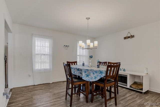 dining space featuring wood-type flooring and a notable chandelier