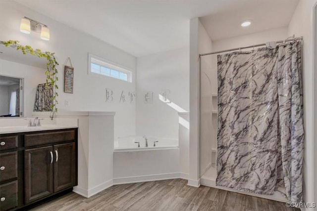 bathroom with vanity, wood-type flooring, and plus walk in shower