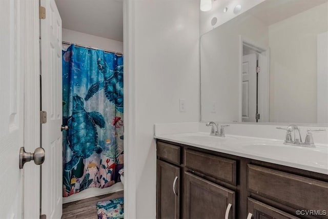 bathroom with hardwood / wood-style floors, vanity, and walk in shower