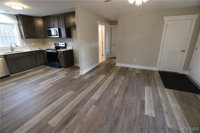 kitchen featuring dark brown cabinetry, ceiling fan, sink, wood-type flooring, and appliances with stainless steel finishes