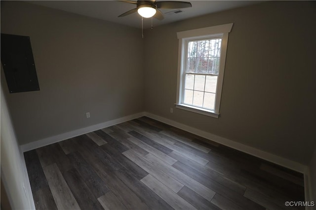 empty room featuring dark hardwood / wood-style flooring, electric panel, and ceiling fan