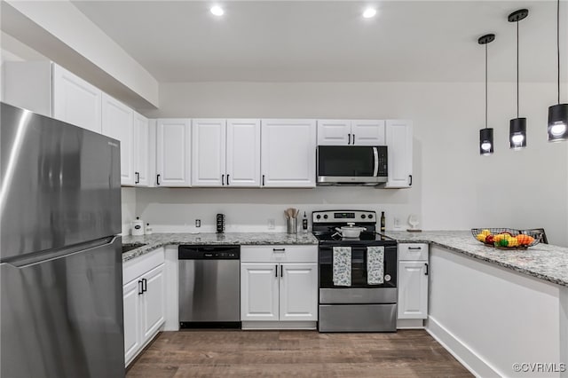 kitchen featuring white cabinets, hanging light fixtures, dark hardwood / wood-style floors, and appliances with stainless steel finishes