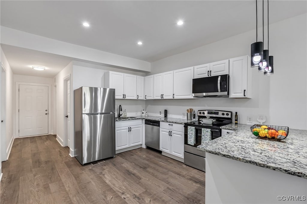 kitchen featuring light stone counters, white cabinets, stainless steel appliances, and dark wood-style flooring