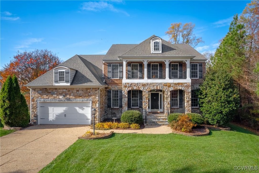 view of front of house featuring a garage, a porch, a balcony, and a front lawn