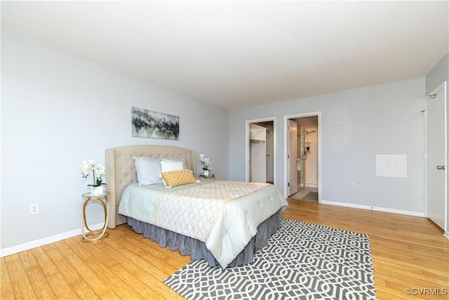 bedroom with a spacious closet, a closet, and hardwood / wood-style floors