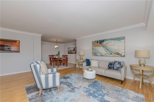 living room with hardwood / wood-style floors, a notable chandelier, and ornamental molding