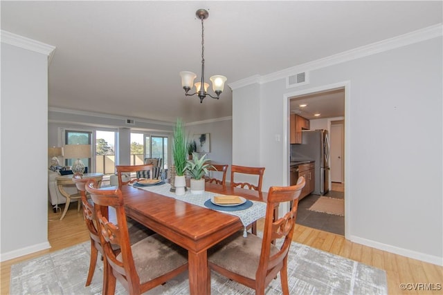 dining space with an inviting chandelier, light hardwood / wood-style flooring, and crown molding