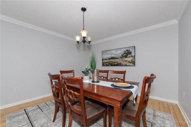 dining area featuring light hardwood / wood-style floors, crown molding, and an inviting chandelier