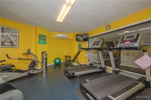 exercise room featuring a textured ceiling and an AC wall unit