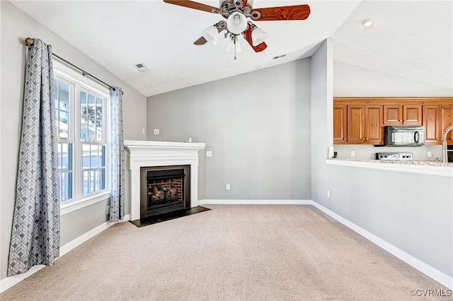 unfurnished living room with ceiling fan, light colored carpet, and lofted ceiling