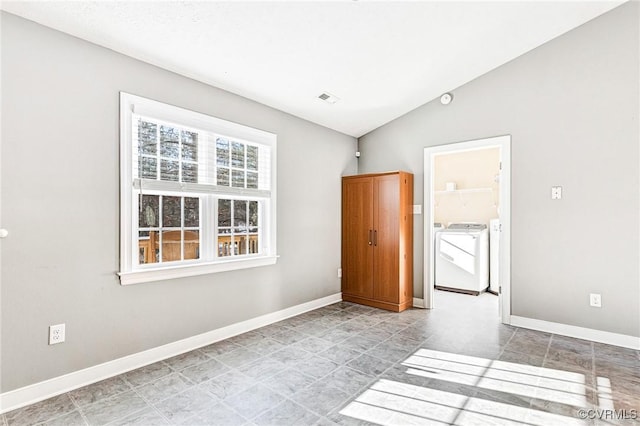 unfurnished room featuring washer and clothes dryer and lofted ceiling