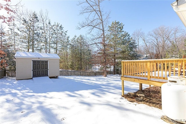 yard covered in snow with a shed and a deck