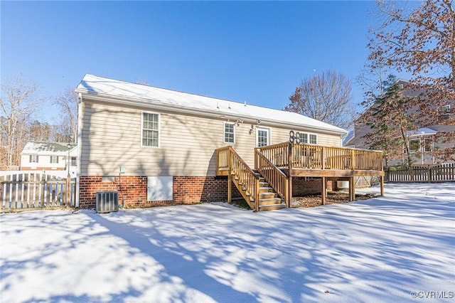 snow covered back of property featuring a wooden deck and central AC unit