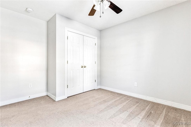 unfurnished bedroom featuring a closet, light colored carpet, and ceiling fan