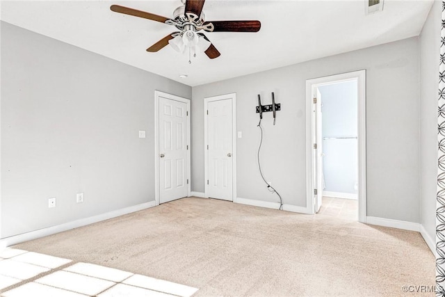 carpeted spare room featuring ceiling fan