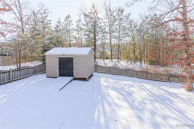 yard layered in snow featuring a storage shed