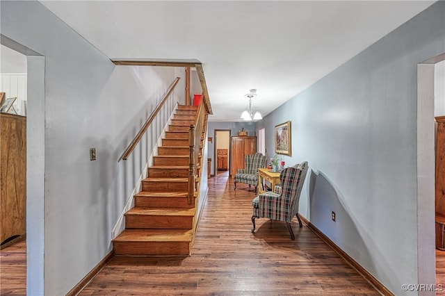 staircase featuring wood-type flooring and a notable chandelier