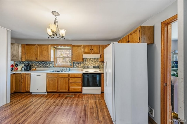 kitchen featuring sink, white appliances, tasteful backsplash, light hardwood / wood-style floors, and decorative light fixtures