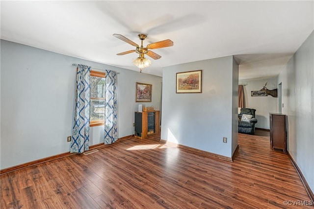 spare room with dark wood-type flooring and ceiling fan