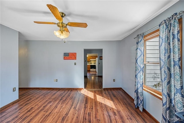 spare room with dark hardwood / wood-style floors and ceiling fan