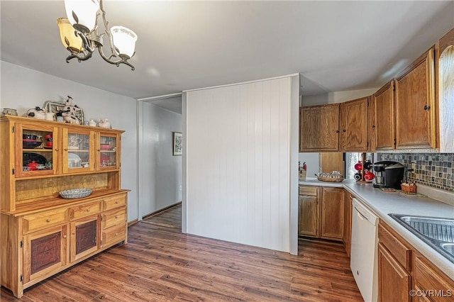 kitchen featuring dark hardwood / wood-style floors, decorative light fixtures, tasteful backsplash, dishwasher, and a notable chandelier