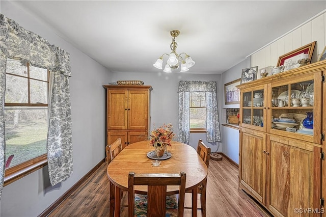 dining area featuring hardwood / wood-style flooring and an inviting chandelier