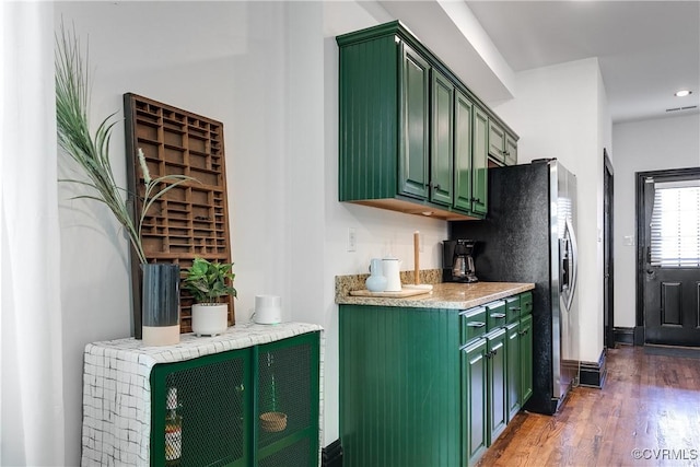 kitchen featuring dark hardwood / wood-style flooring and green cabinetry