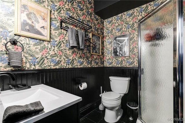 bathroom with tile patterned flooring, toilet, a shower with shower door, and sink