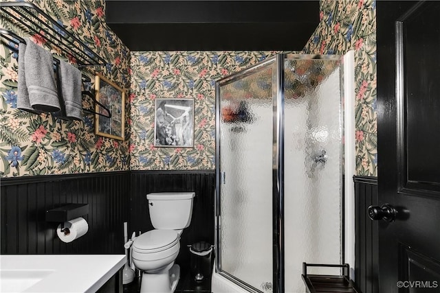 bathroom featuring vanity, toilet, walk in shower, and wooden walls