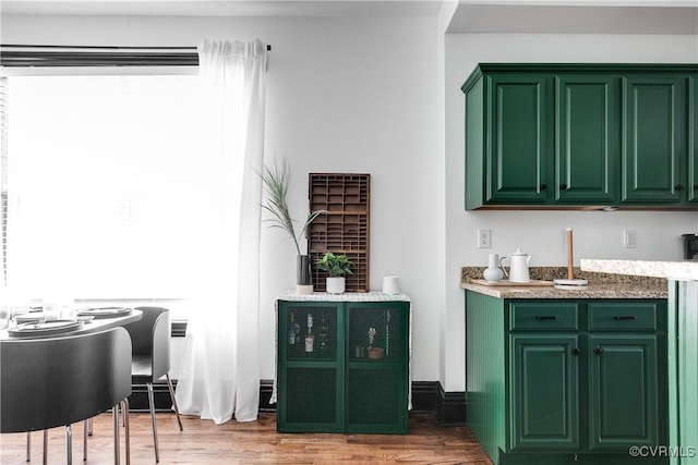 bar with hardwood / wood-style floors and green cabinets