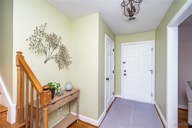 tiled entryway with a chandelier