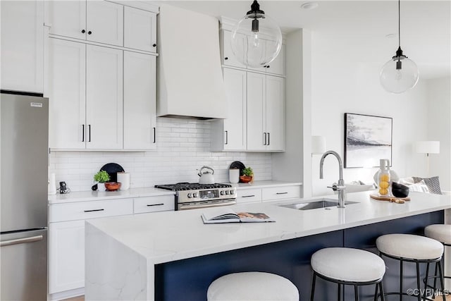 kitchen with a center island with sink, decorative light fixtures, sink, and stainless steel appliances