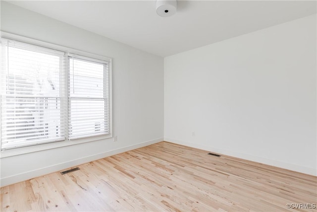 spare room with a wealth of natural light and light hardwood / wood-style flooring