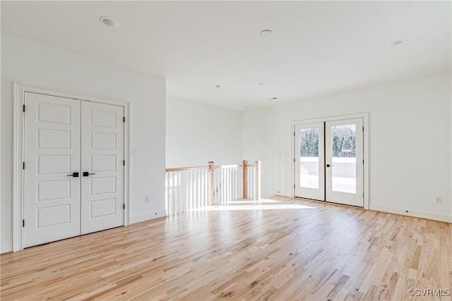 empty room with french doors and light hardwood / wood-style floors