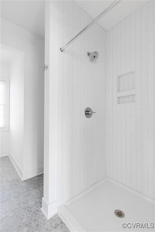 bathroom with tile patterned flooring and tiled shower