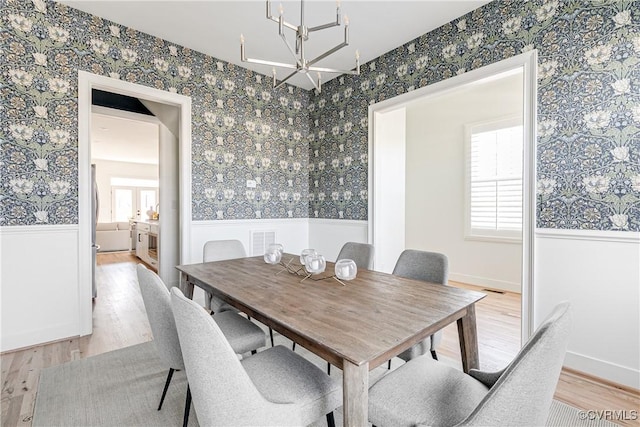 dining area with a notable chandelier and light wood-type flooring