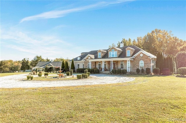 cape cod-style house with a front yard and covered porch