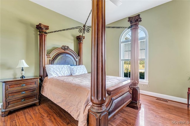 bedroom with lofted ceiling and hardwood / wood-style flooring