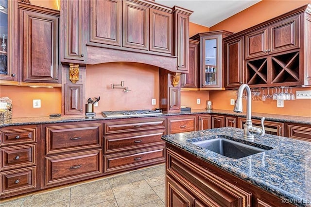 kitchen featuring light tile patterned floors, stainless steel gas cooktop, dark stone counters, and sink