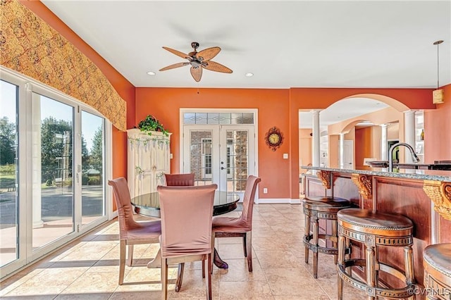 tiled dining room featuring french doors, decorative columns, and ceiling fan