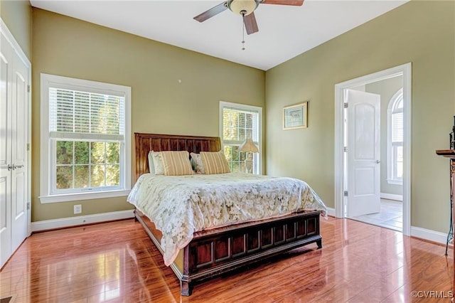 bedroom with light wood-type flooring, ensuite bathroom, and ceiling fan