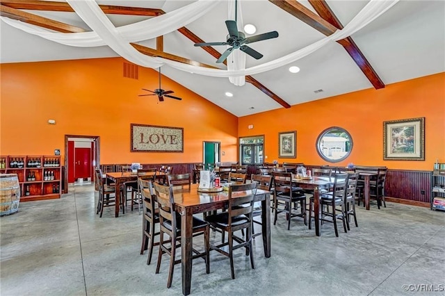 dining room featuring concrete flooring, beam ceiling, high vaulted ceiling, and ceiling fan